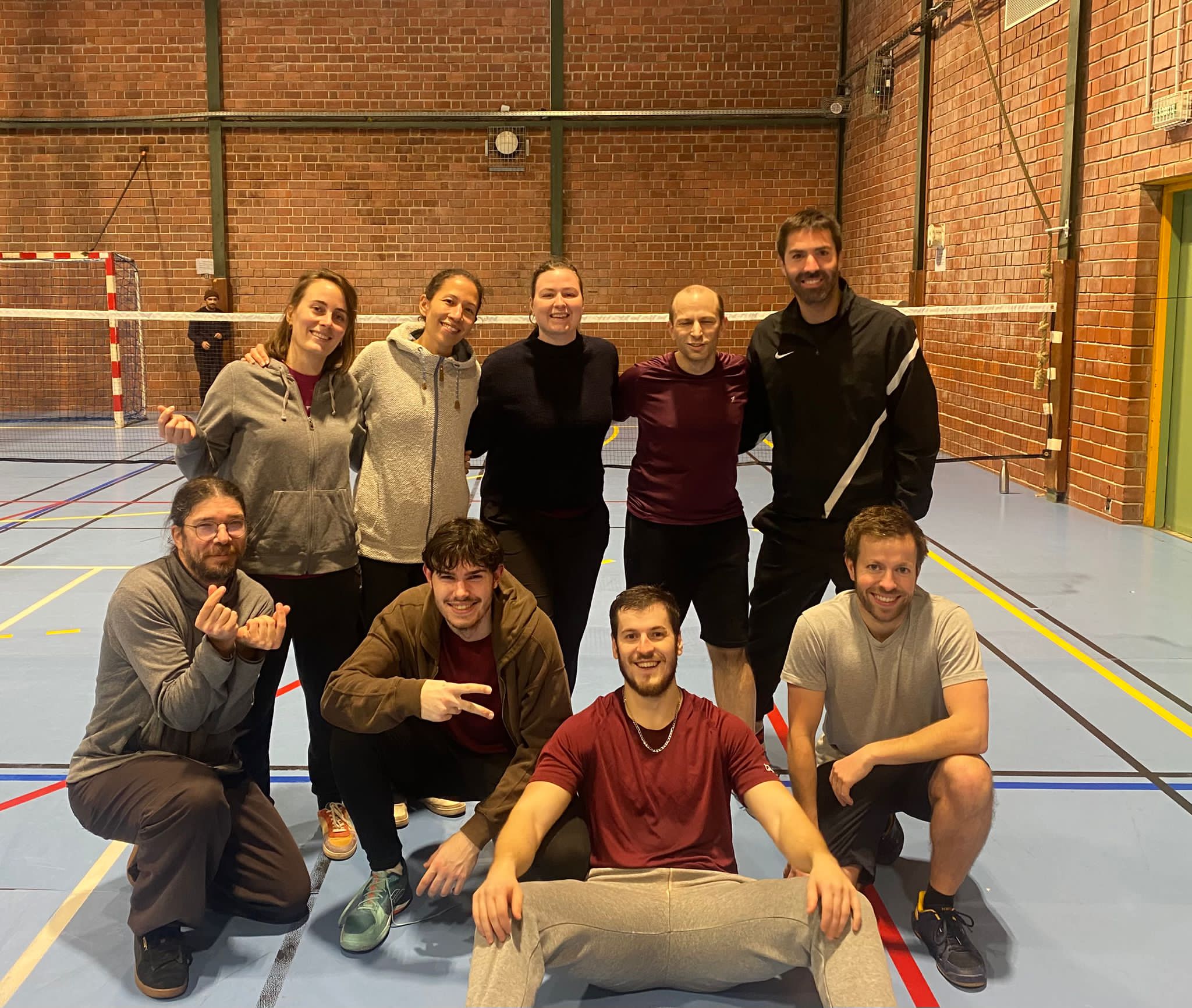 Équipe de joueurs posant sur un terrain après une rencontre de badminton